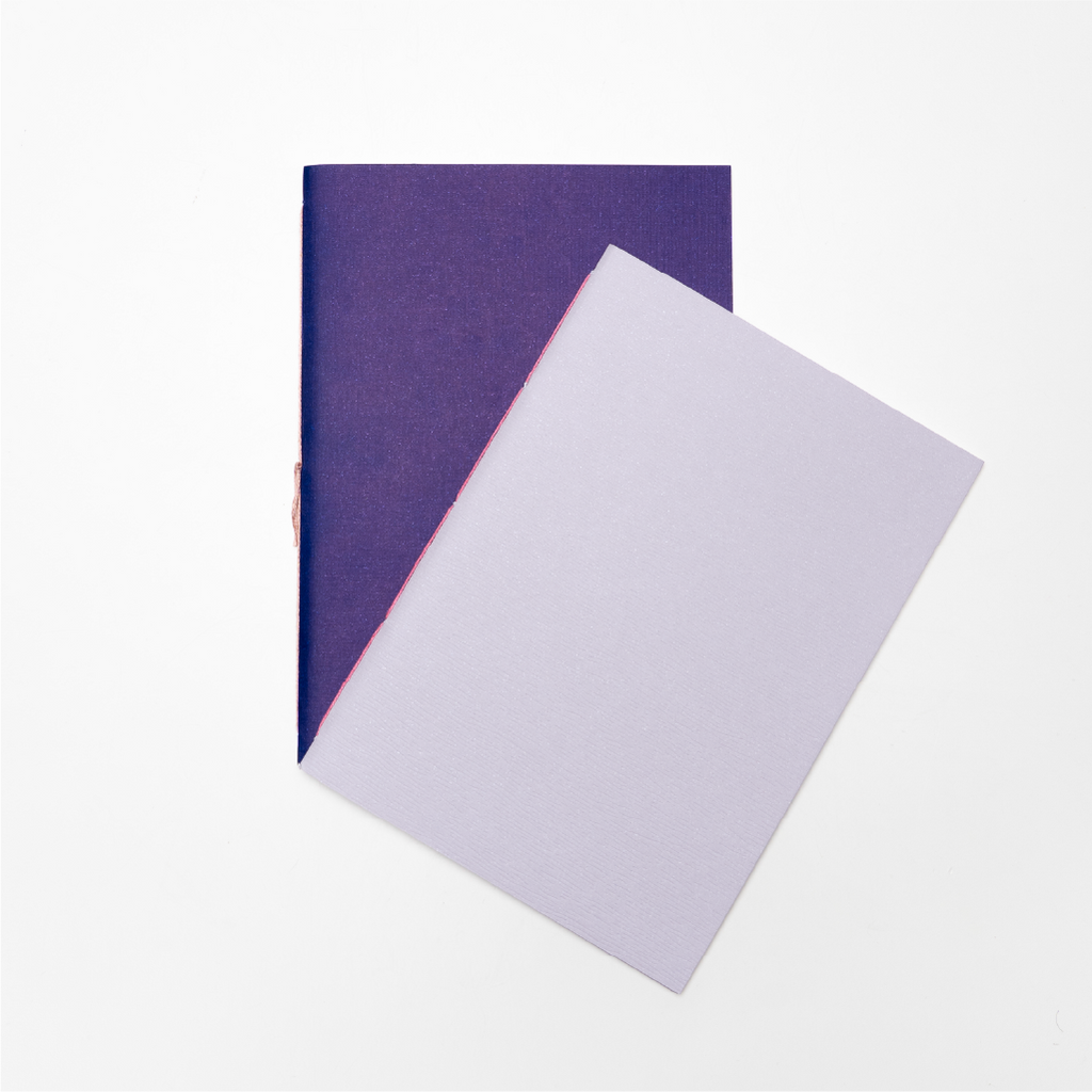 Libretas Eco abiertas sobre mesa, dos interiores que se complementan, Nómade Editorial